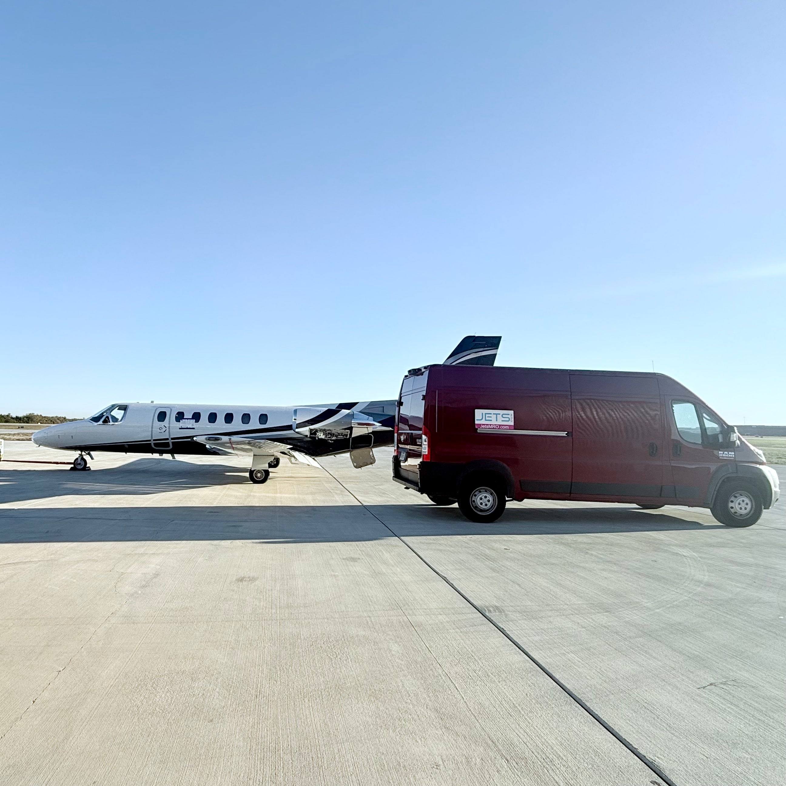 Maroon Jets MRO service van parked beside a Cessna Citation on an open ramp under a clear blue sky