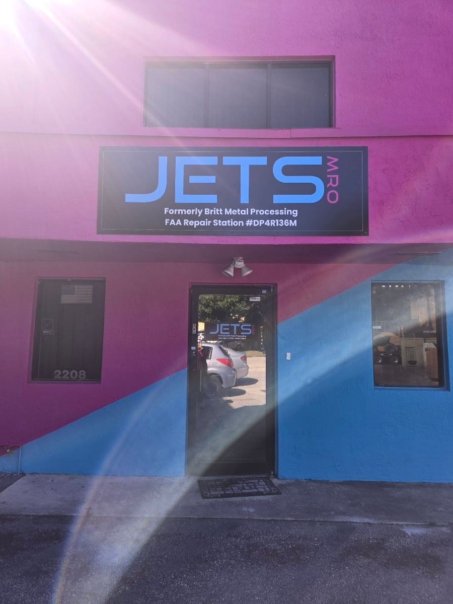 Jets MRO building in Hialeah, Florida: pink and blue facade with a sign naming FAA Repair Station DP4R136M