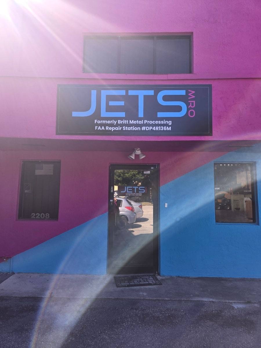 Jets MRO building in Hialeah, Florida: pink and blue facade with a sign naming FAA Repair Station DP4R136M